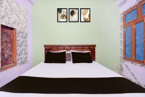 a bedroom with a white bed with two pillows at HOTEL O AWARA GRAND PALACE in Pratāpgarh +21 photos