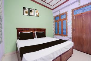 a bedroom with a bed and a window at HOTEL O AWARA GRAND PALACE in Pratāpgarh