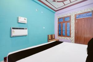 a bedroom with a bed and a blue wall at HOTEL O AWARA GRAND PALACE in Pratāpgarh