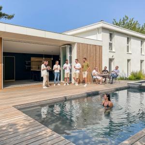 a group of people standing in the swimming pool of a house at Villa d'Exception avec piscine & spa à Mérignac - Aeroport - Tram direct centre - Aéroparc Business Center Mérignac - Airbus Thales Safran - Hôpital Charles Perrens - Hôpital Pellegrin - ZI Espace Mérignac Phare in Mérignac