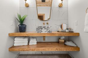 a bathroom with a wooden shelf with towels and a mirror at Sommer House Inn-Aloha Room in Jasper
