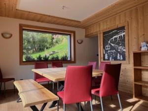 モルジヌにあるChalet "Le 19 x 27"のダイニングルーム(テーブル、赤い椅子付)
