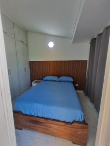 a bedroom with a large bed with a blue blanket at Casa Narad Valledupar in Valledupar