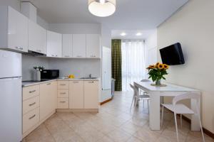 eine Küche mit weißen Schränken und einem Tisch mit einer Blumenvase in der Unterkunft Yerevan Elite Stay - Republic Square in Yerevan