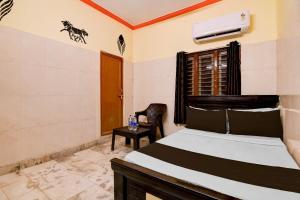 a bedroom with a bed and a chair at Hotel O D Stay Inn in Rushikonda