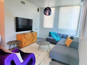 a living room with a couch and a flat screen tv at Hollywood Homes Free parking close to all things LA in Los Angeles