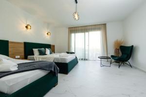 a hotel room with two beds and a chair at Sahat Kula Residence Hotel in Ulcinj +97 photos