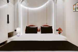 a bedroom with a white bed with two pillows at Hotel O Parth in Ayodhya