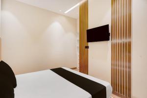 a bedroom with a bed and a tv on the wall at Hotel O Parth in Ayodhya