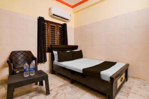 a bedroom with a bed and a chair and a table at Hotel O D Stay Inn in Rushikonda