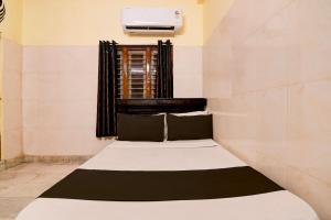 a small bed in a room with a window at Hotel O D Stay Inn in Rushikonda