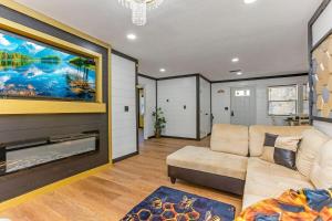 ein Wohnzimmer mit einem Sofa und einem großen TV in der Unterkunft Buzz Inn with Hot tub Sauna fire pit, Roof top Deck in Hocking Hills in South Bloomingville
