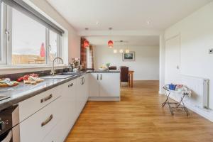 LlanuwchllynにあるGlan Donauの白いキャビネットと大きな窓のあるキッチン +28枚の写真