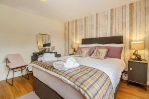 LlanuwchllynにあるGlan Donauのタオルが敷かれた大きなベッドのある寝室