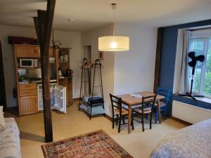 a living room with a table and a kitchen at SAGE Studio in Treignac