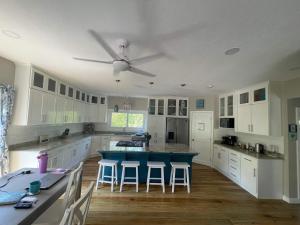 a kitchen with white cabinets and a blue island at Casa Viola - Utila in Utila