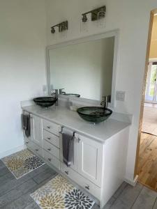 a bathroom with two sinks and a large mirror at Casa Viola - Utila in Utila