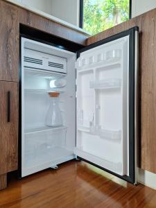 an empty refrigerator with its door open in a kitchen at FORESTA 2 - Cabaña moderna con vista a la piedra in Chiquinquirá +20 photos