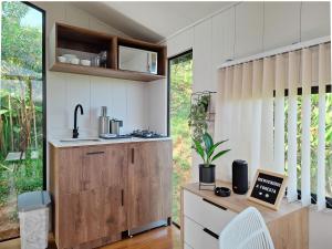 a kitchen with white walls and a wooden cabinet at FORESTA 2 - Cabaña moderna con vista a la piedra in Chiquinquirá