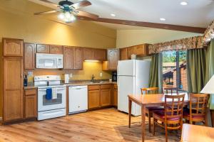 eine Küche mit einem Tisch und einem weißen Kühlschrank in der Unterkunft Oak-Lodge - Roundhouse Resort and Spa in Indian Pine + 6 Fotos