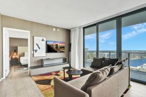 een woonkamer met een bank en grote ramen bij 2BR & 2BA Corner Suite Ocean Views at Hyde Beach House - NO FEES till Dec 31, 2025 in Hollywood