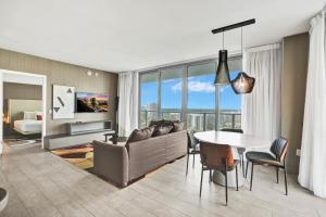 een woonkamer met een bank en een tafel bij 2BR & 2BA Corner Suite Ocean Views at Hyde Beach House - NO FEES till Dec 31, 2025 in Hollywood