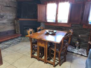 a wooden table and chairs in a room with a fireplace at Borda Cucut-HUT4-08181 in La Massana