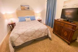 Un dormitorio con una cama y un televisor de pantalla plana. en The Calm at Emerald Bay, en Lake Ozark