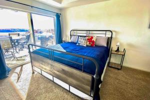 Un dormitorio con una cama con sábanas azules y un balcón. en The Calm at Emerald Bay, en Lake Ozark 15 fotos más