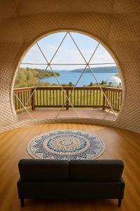 a living room with a large window and a couch at Baddeck Domes in Baddeck