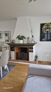 a living room with a fireplace and a table at Vivenda Soalheira in Fajã de Baixo