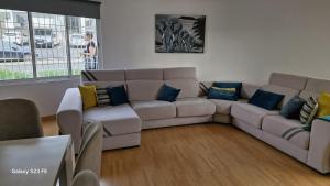 a living room with a couch and blue pillows at Vivenda Soalheira in Fajã de Baixo