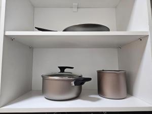 two pots and pans on a shelf in a kitchen at Easy Access Apartment - Ciudad del Este in Ciudad del Este