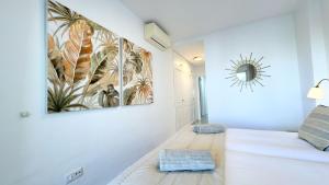 a bedroom with a large bed with two paintings on the wall at Apartamento en primera línea de playa, Mi Capricho in Sitio de Calahonda +41 photos