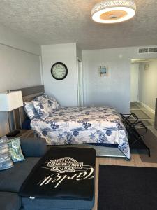 a bedroom with a bed and a couch and a clock at Daytona Inn in Daytona Beach +36 photos