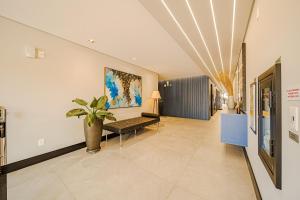 a hallway with a bench and a painting on the wall at Mingus Residencial Flipchave MIN000 in Joinville +201 photos