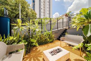 a patio with a bench and a table and some plants at Mingus Residencial Flipchave MIN000 in Joinville