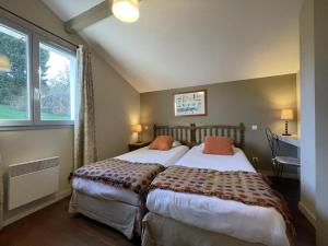 ein Schlafzimmer mit zwei Betten und einem Fenster in der Unterkunft Ohiana in Villefranque