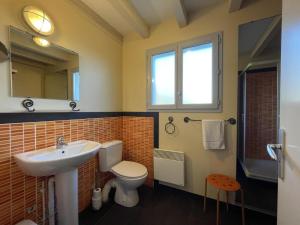 ein Badezimmer mit Waschbecken, Toilette und Spiegel in der Unterkunft Ohiana in Villefranque + 13 Fotos