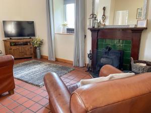 een woonkamer met een bank en een open haard bij The Smiddy in Glasserton