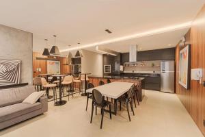 a kitchen and living room with a table and chairs at Elyseés Residencial Flipchave ELY000 in Joinville