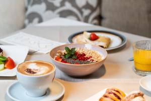 a table with a bowl of food and a cup of coffee at Hotel COSMEA 4 Stars - Your Dolomites experience in Ortisei +113 photos