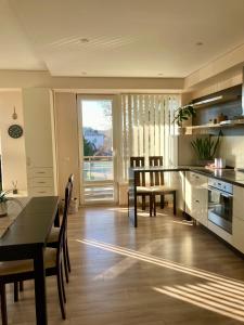 a kitchen and dining room with a table and chairs at Sunny Lotus Apartamentai in Druskininkai
