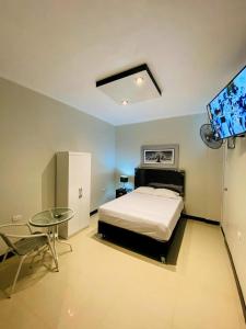 a bedroom with a bed and a table and a tv at Descubre un lugar pensado para ti in Sechura
