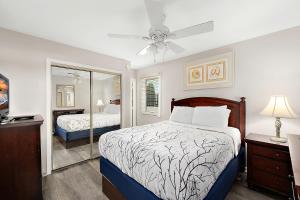 une chambre avec deux lits et un ventilateur de plafond dans l'établissement Club Ocean Villas II, à Ocean City 17 autres photos