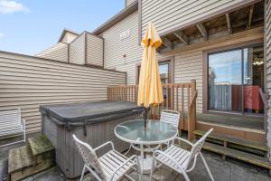 un patio avec une table, des chaises et un parasol dans l'établissement Club Ocean Villas II, à Ocean City