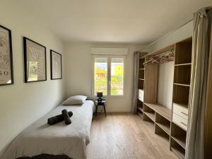 a bedroom with a bed and shelves and a window at Ker Heol - Maison au Nord Finistère in Lesneven