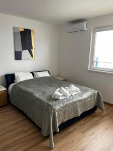 a bedroom with a bed with two towels on it at Anna apartman in Niš