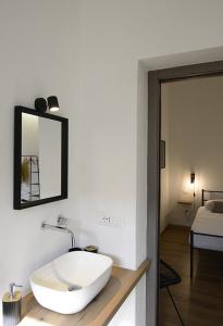 een badkamer met een wastafel en een spiegel aan de muur bij S'Apposentu 15 in Monserrato