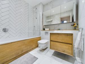 a bathroom with a toilet and a tub and a sink at Luxury Unique 2bedroom city centre in Manchester +20 photos